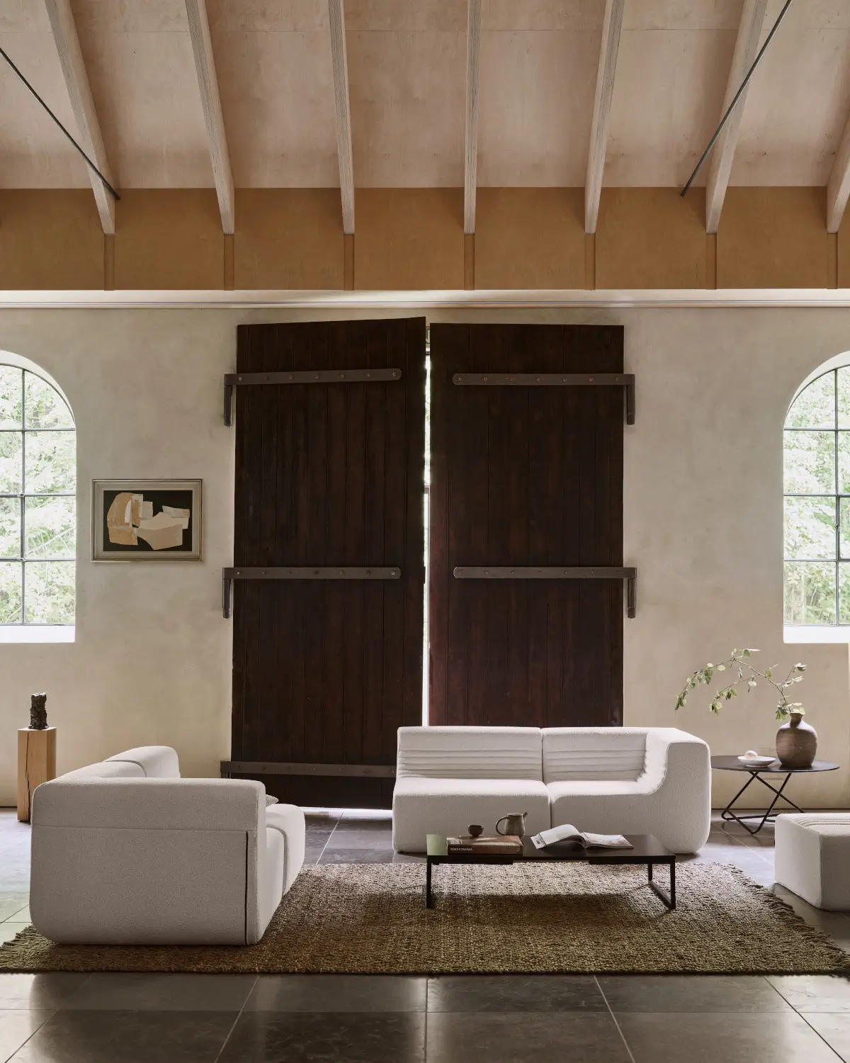 Softline Loft Sofa in Weiß als modulare Sitzgruppe mit gegenüberstehenden Sofaelementen in einem großzügigen Wohnambiente mit Teppich und Couchtisch.