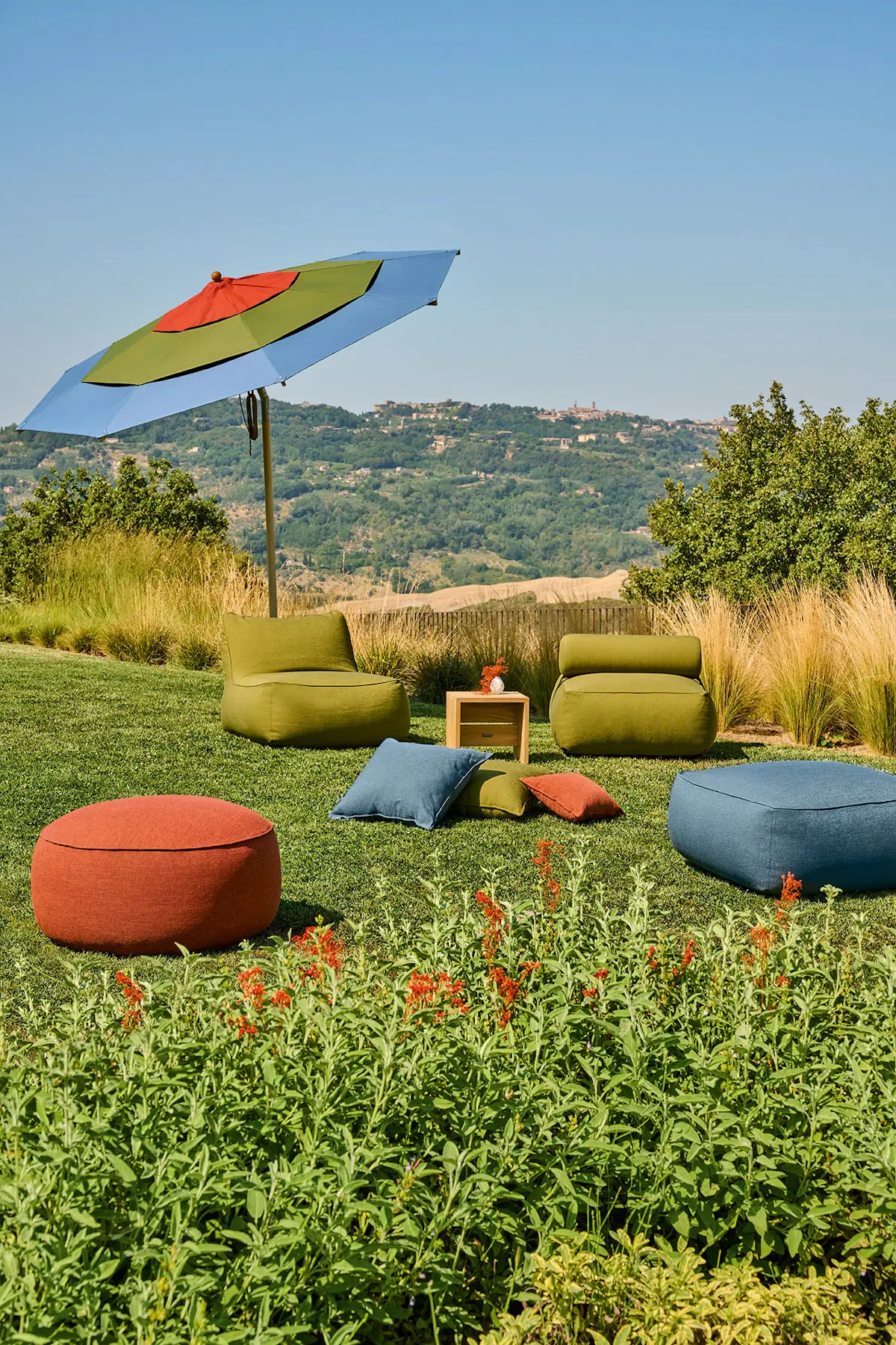 Gekippter Weishäupl Klassiker Schirm 300 cm in Terracotta, Oliv und Taubenblau über einer Lounge im Garten