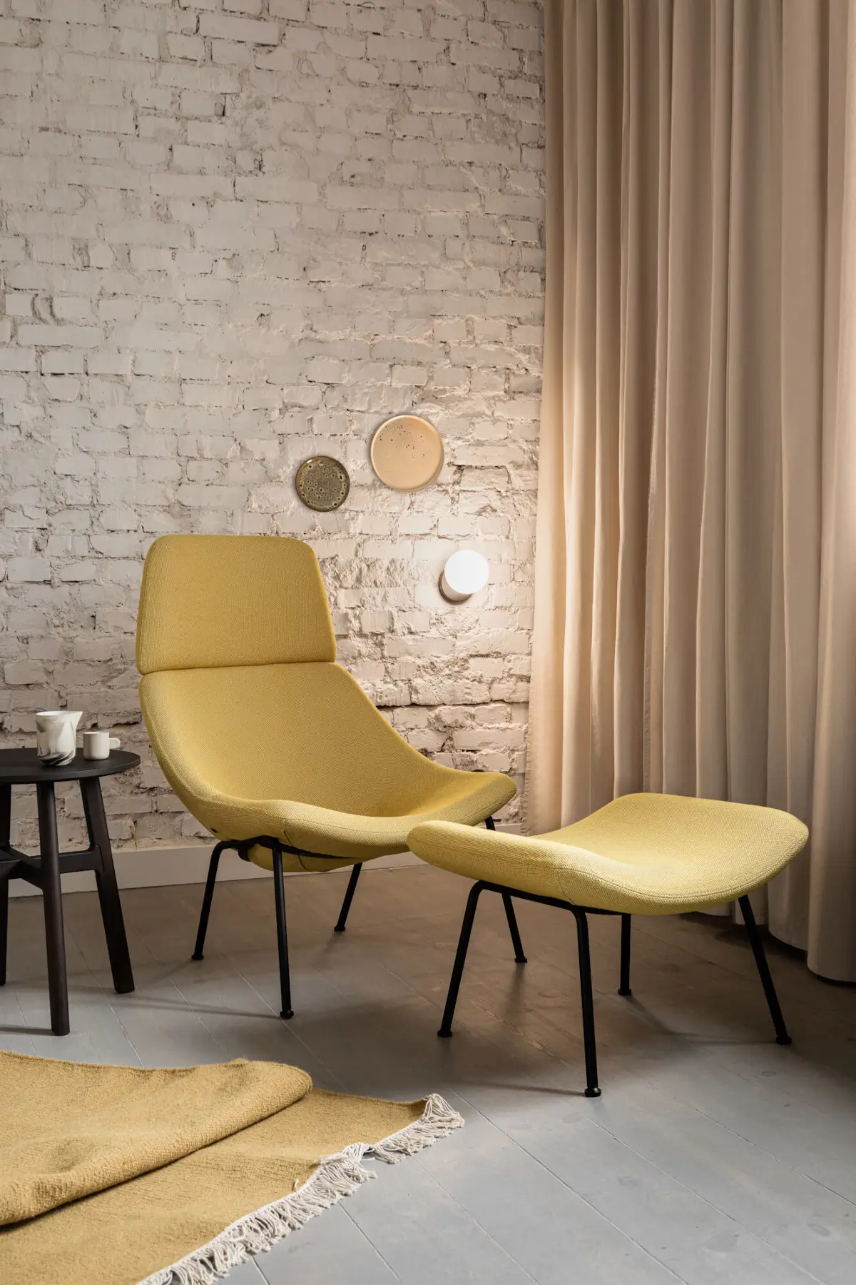 Noti Mishell XL Sessel mit Rohrbeinen und Fußhocker in modernem Wohnambiente