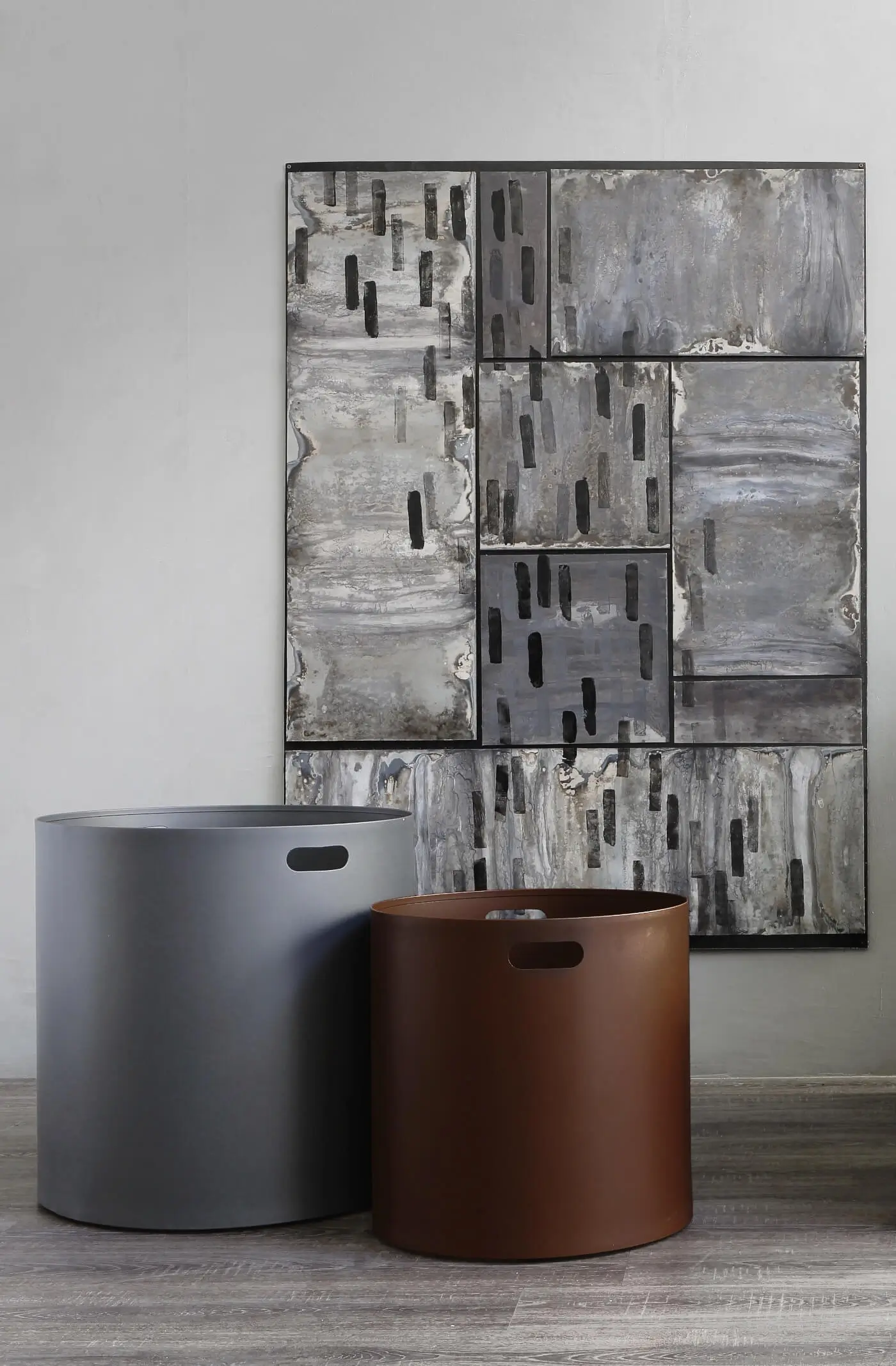 Zeus Irony Pot Blumentöpfe als moderne Pflanzgefäße in Gunmetal und Rost vor einer dekorativen Wandgestaltung im Wohnbereich.