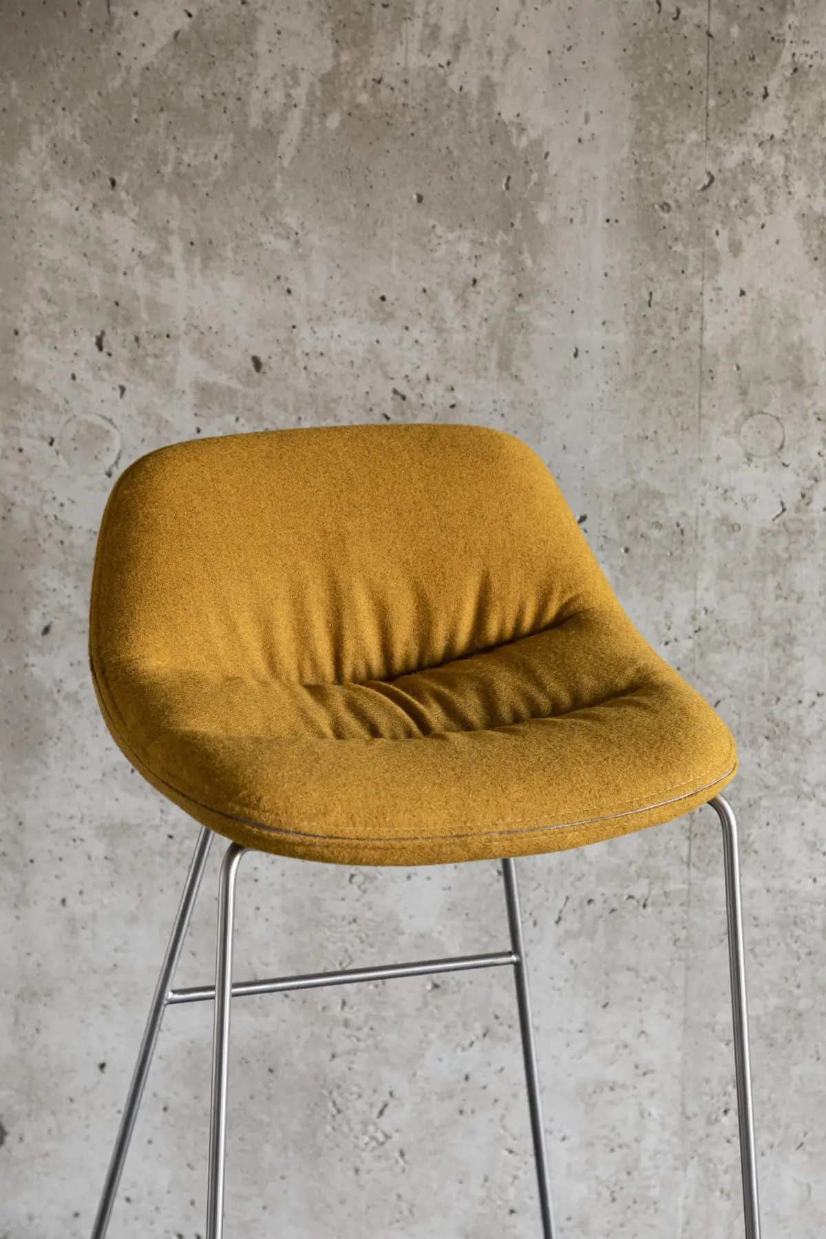 Noti Mishell Soft Barhocker Höhe 79 cm in Gelb vor moderner Betonwand