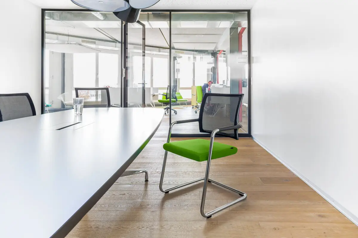 Girsberger Camiro Freischwinger mit Netzrücken an einem großen Konferenztisch im modernen Büro.
