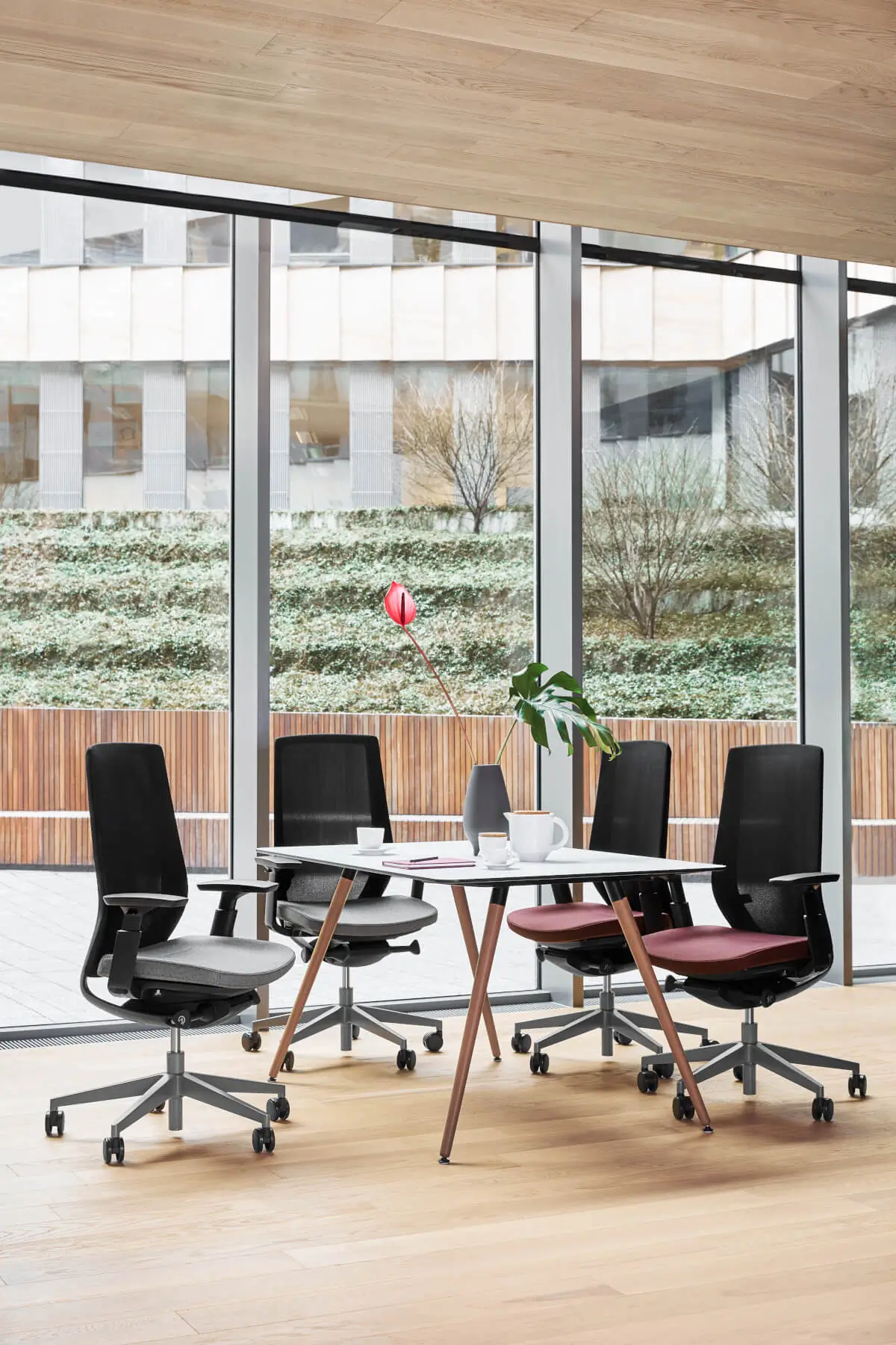 Profim Accis Pro Bürostühle mit Netzrücken an einem Tisch im hellen Konferenzraum