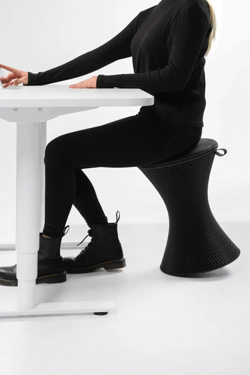 Wagner 3D One Pure S Hocker in Schwarz im Einsatz an einem höhenverstellbaren Schreibtisch für ergonomisches und aktives Sitzen.