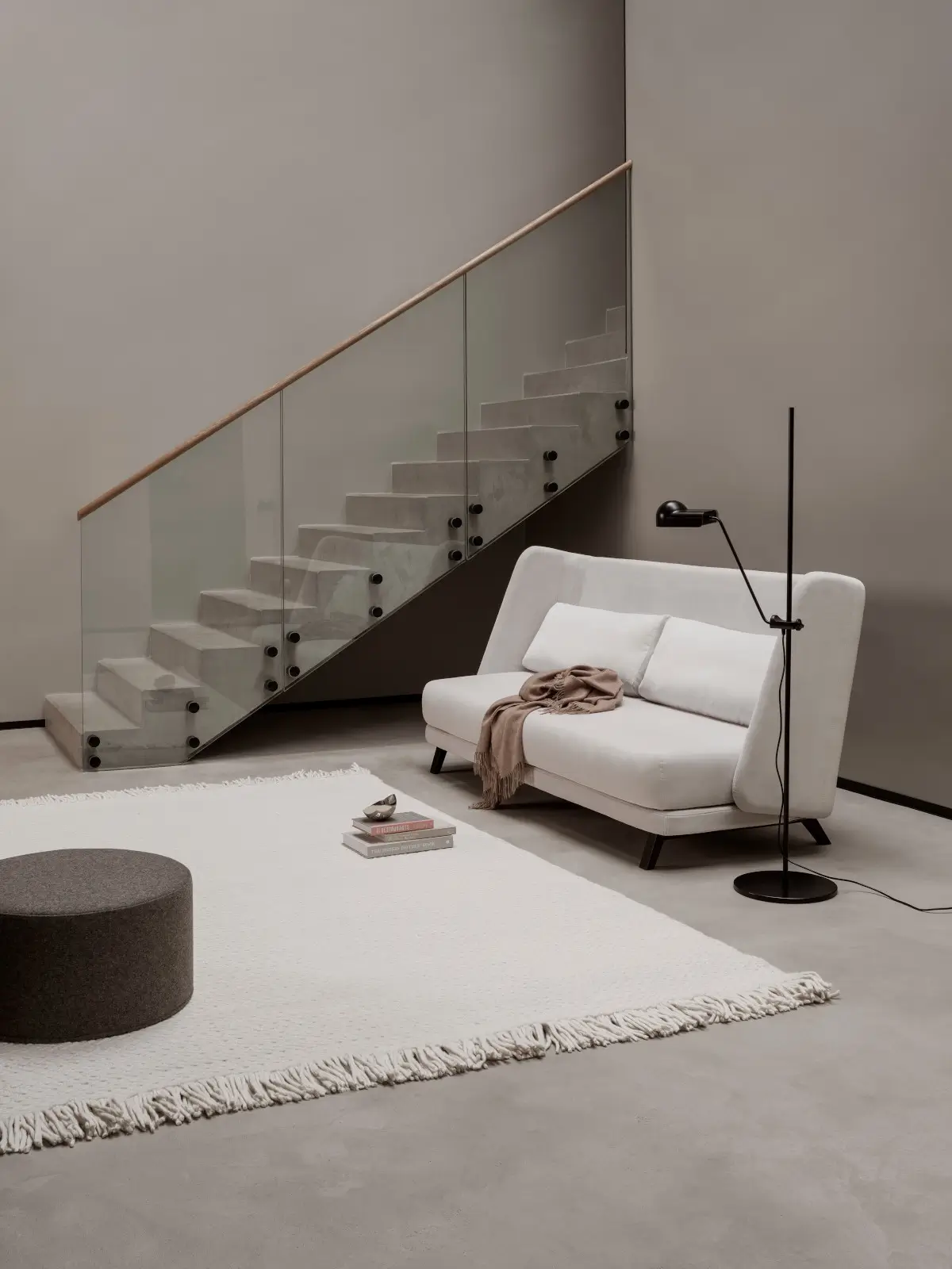 Softline Jason Sofa in Weiß in einem modernen Wohnambiente neben einer Glastreppe, schwarzer Stehleuchte und hellem Teppich.