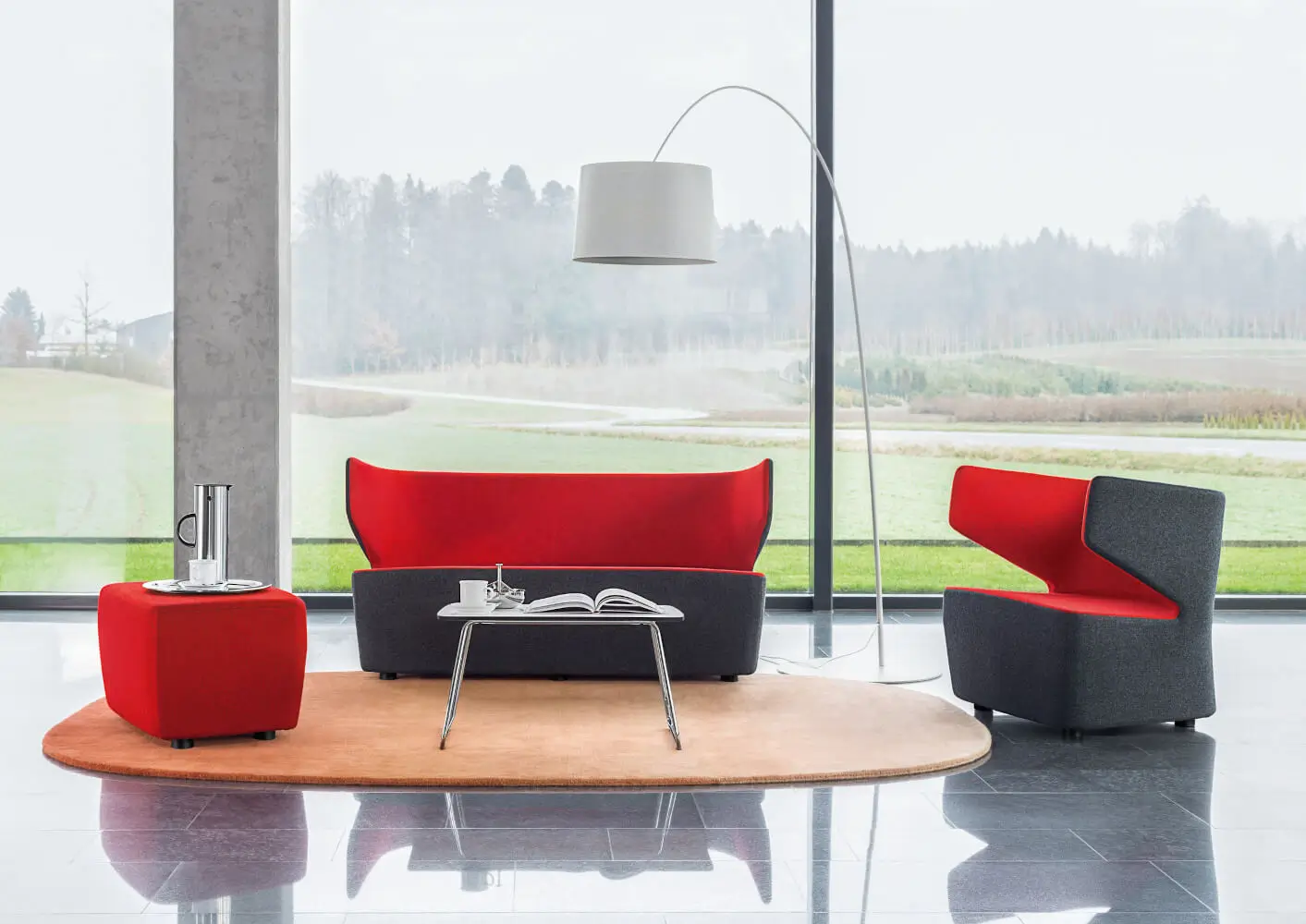 Girsberger Pablo Sessel mit passendem Sofa und Pouf als komfortable Sitzgruppe in einem hellen Aufenthaltsbereich.