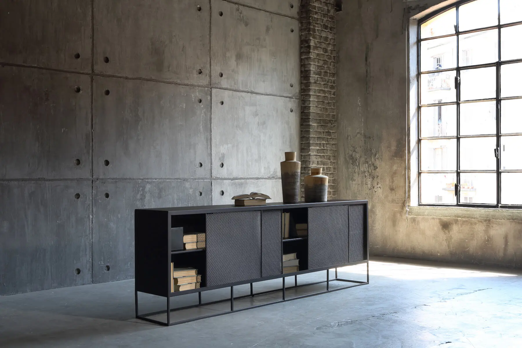 Zeus Isotta Sideboard mit offenen und geschlossenen Fächern vor einer großen Fensterfront.