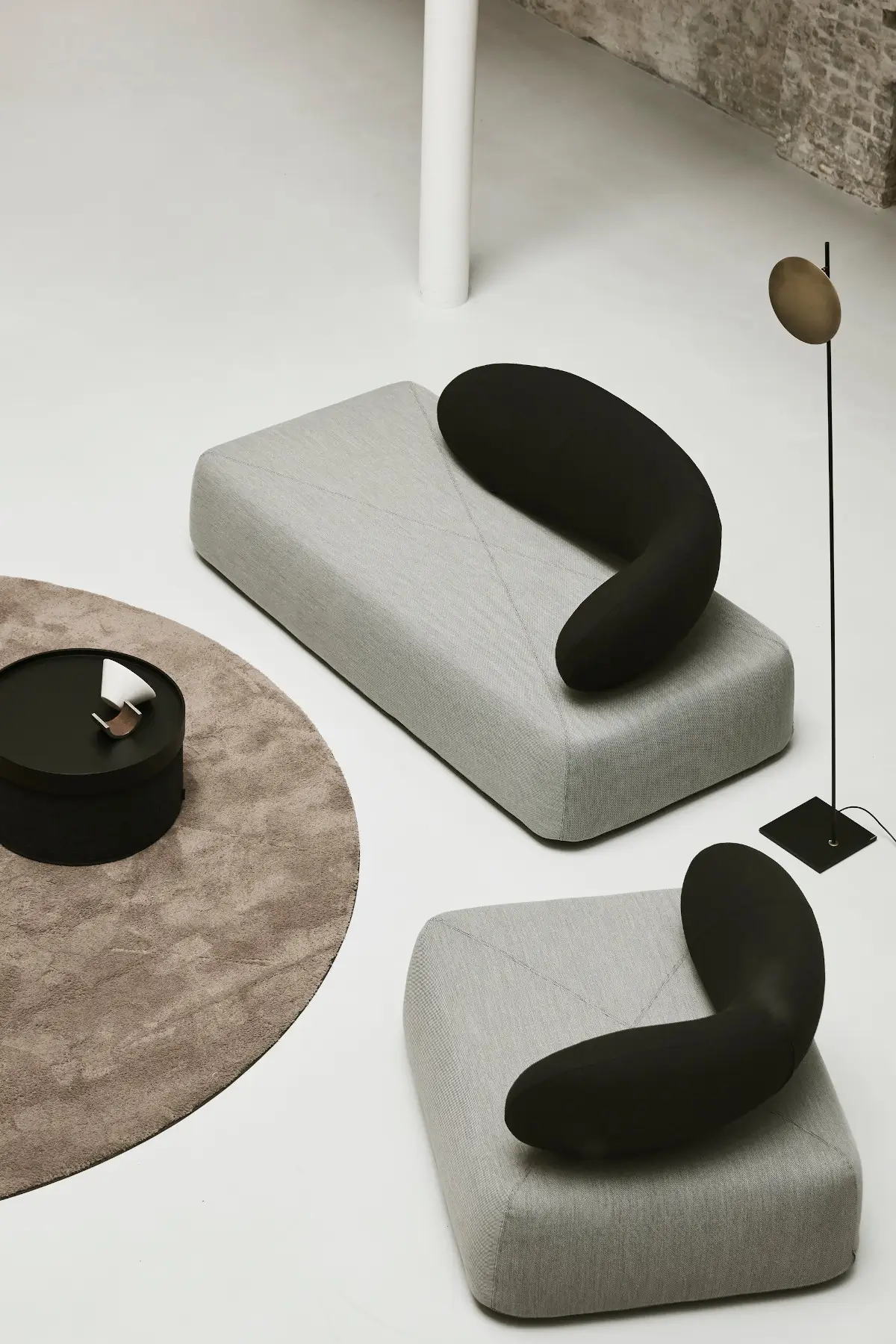 Zwei Softline Chat Sofas in Hellgrau mit schwarzen geschwungenen Rückenlehnen aus erhöhter Perspektive in modernem Wohnambiente.