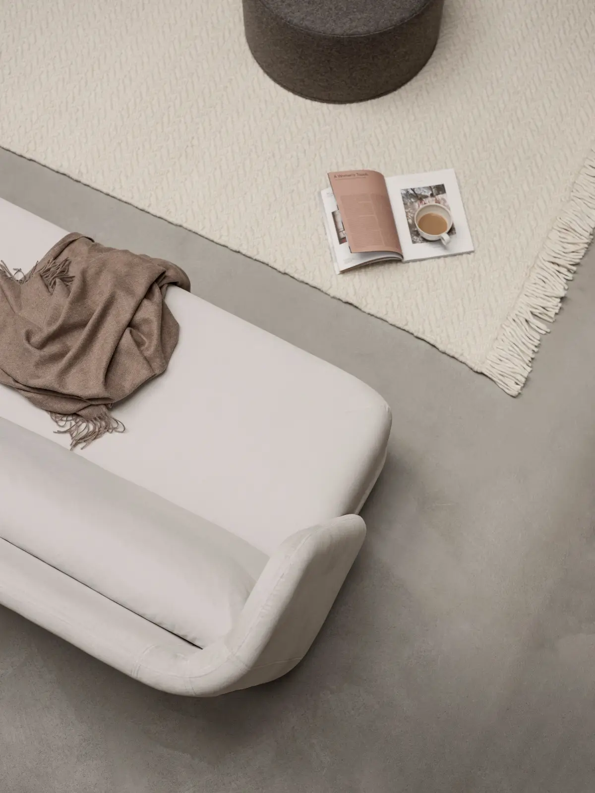 Softline Jason Sofa in Weiß aus erhöhter Detailperspektive mit weich gerundeter Armlehne und Sitzfläche neben einem hellen Teppich.