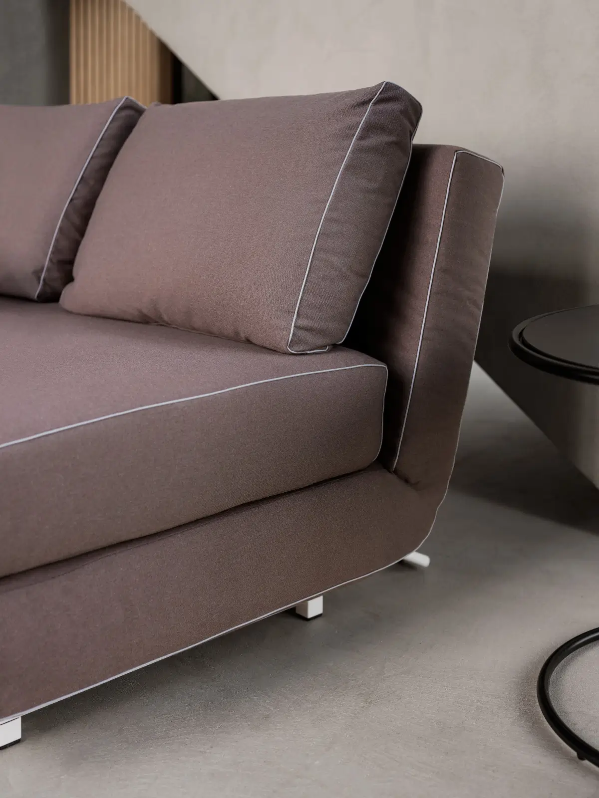Softline City Sofa 2,5-Sitzer in Braun als Detailansicht mit gepolsterten Rückenkissen, Sitzfläche und hellen Kontrastnähten.