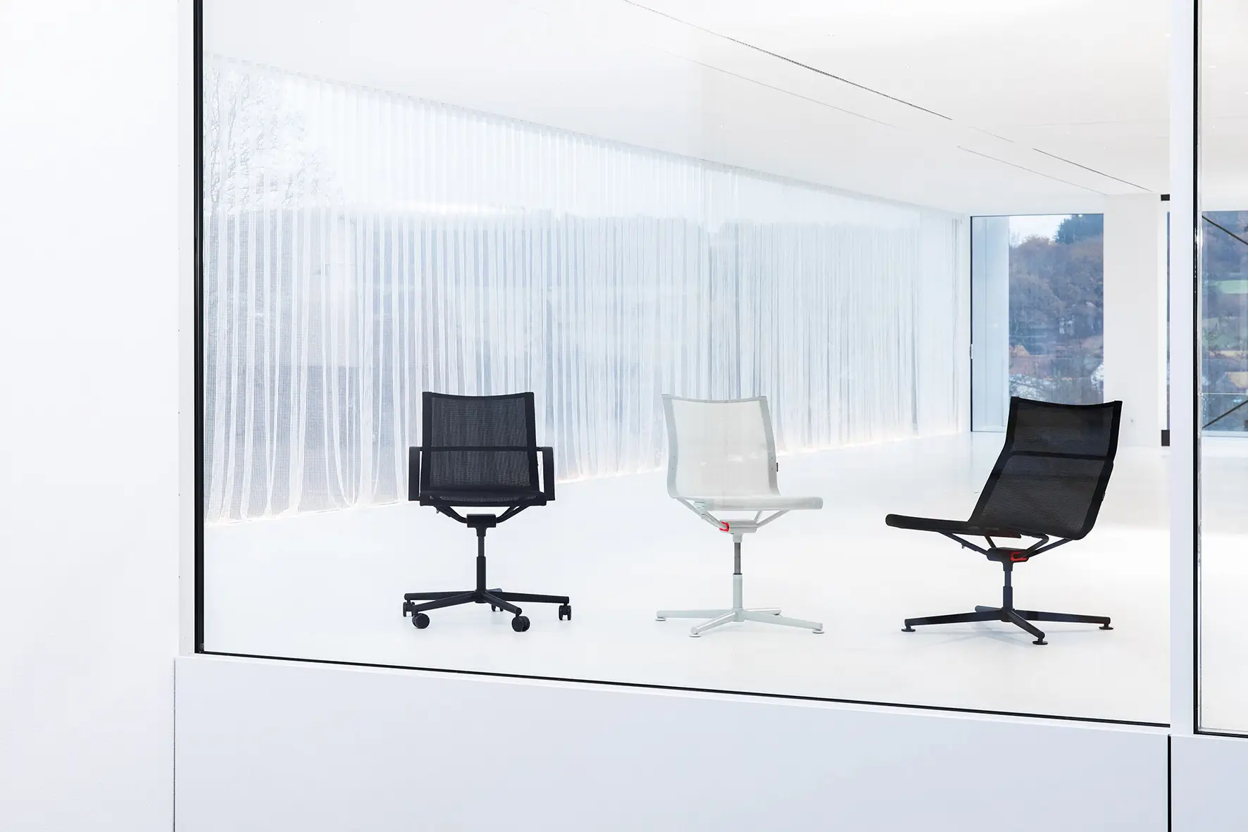 Wagner d1 Office Stuhlkollektion mit Besucherstühlen und Bürostuhl in Schwarz und Weiß in modernem Ausstellungsraum.