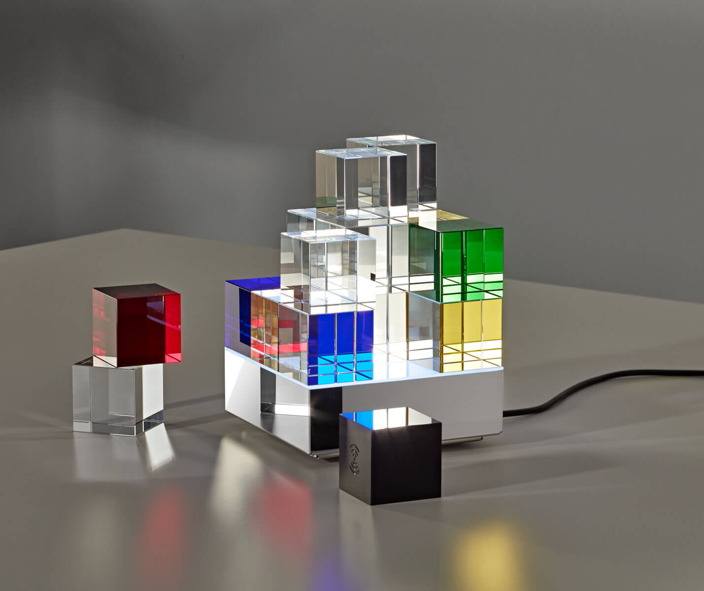 Kabelloser Steuerwürfel der Tecnolumen Cubelight Move MSCL 3 Tischleuchte neben der Leuchte