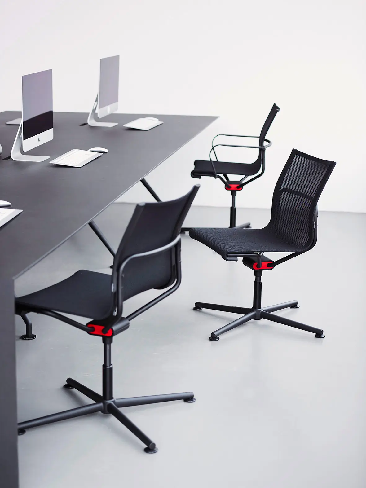 Mehrere Wagner d1 Office Besucherstühle in Schwarz an einem modernen Konferenztisch mit Design-Arbeitsplätzen.