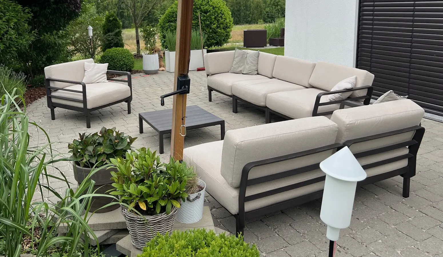 Modulare Sitzlandschaft mit Nardi Maximo Gartensofa und Sesseln auf einer Terrasse