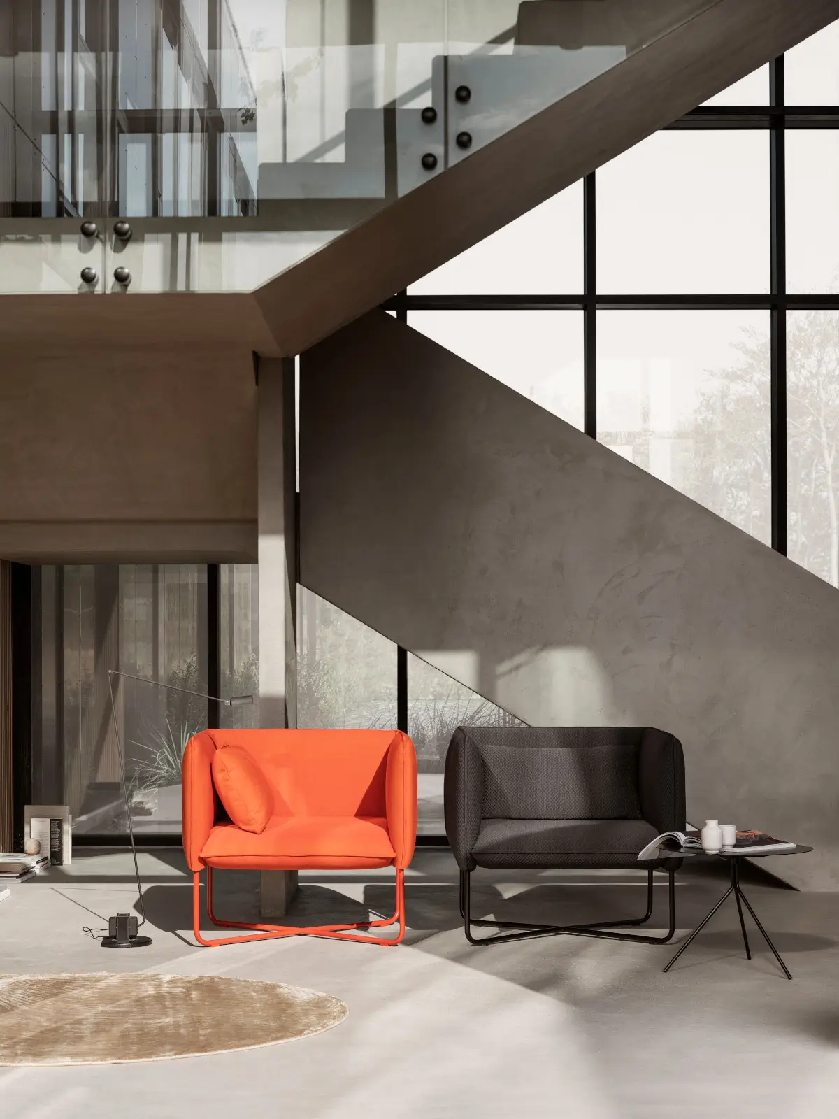 Zwei Softline Groove Sessel in Orange und Anthrazit mit Metallgestell in einem modernen, lichtdurchfluteten Wohnambiente neben einem Beistelltisch.