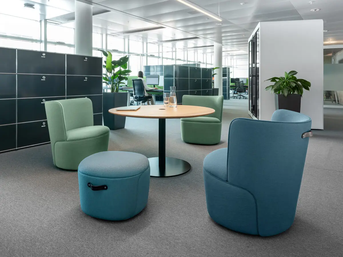 Girsberger Tala Rundtisch mit gepolsterten Sitzmöbeln als Treffpunkt in einem modernen Büro.