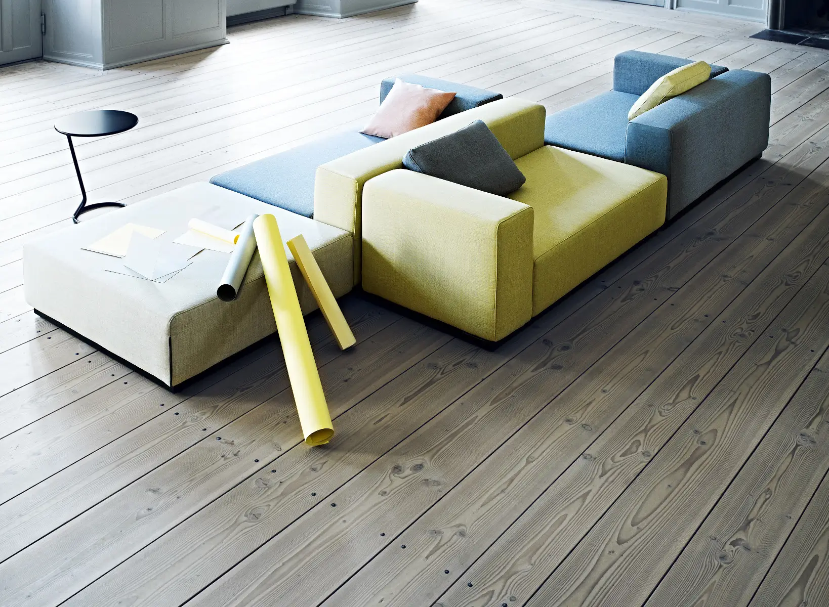Softline Nevada Hocker als Teil einer modularen Sitzlandschaft in Blau, Gelb und Hellgrau auf Holzboden in einem hellen Wohnambiente.