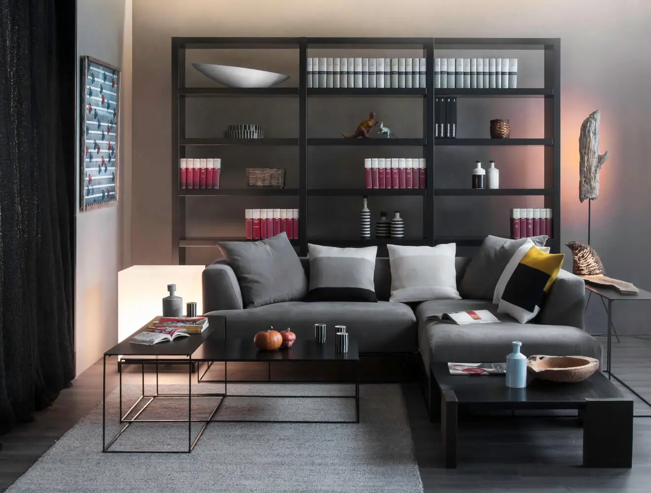 Vor einer modernen Wohnwand mit Bücherregal bildet der Zeus Ironwood Couchtisch den funktionalen Mittelpunkt der Sitzgruppe.