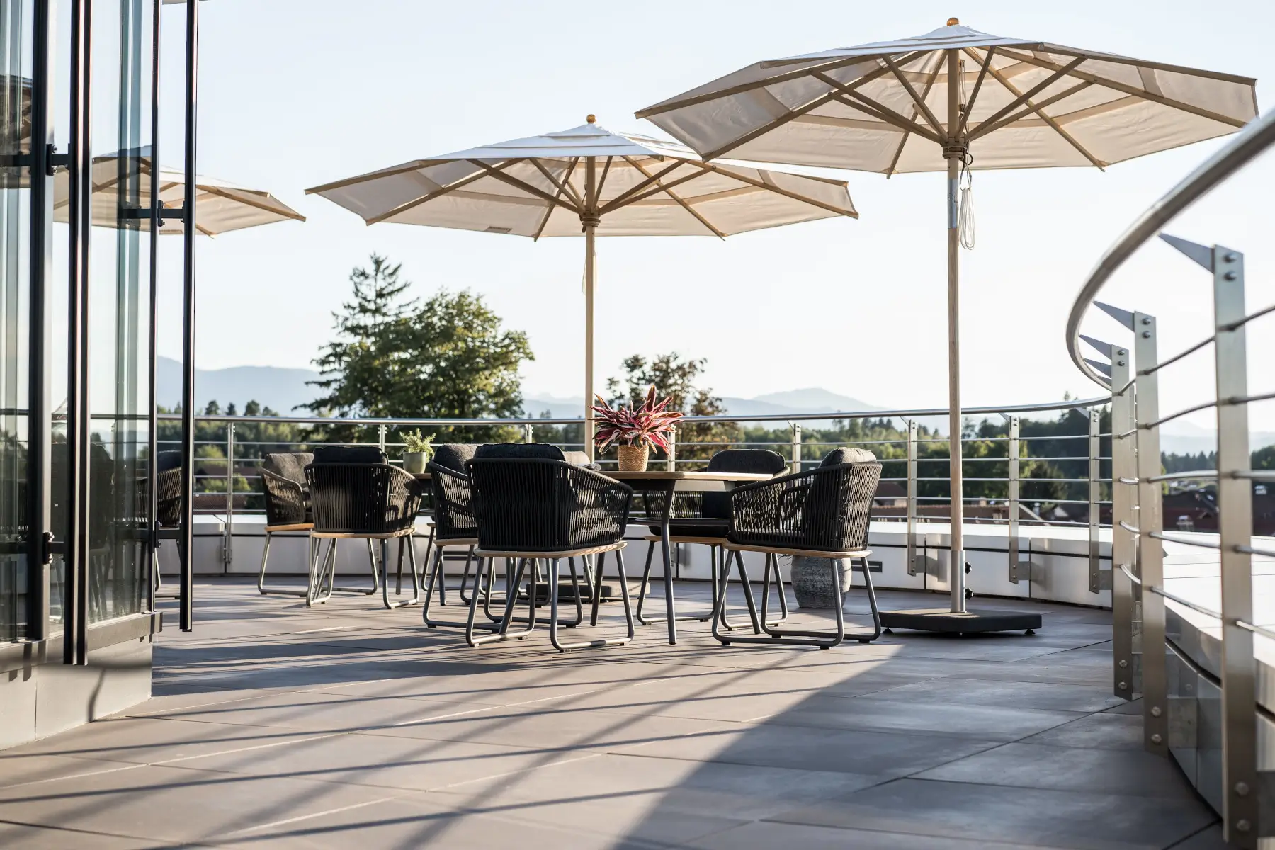 Weishäupl Klassiker Schirm 300 cm über einer Sitzgruppe auf einer modernen Dachterrasse