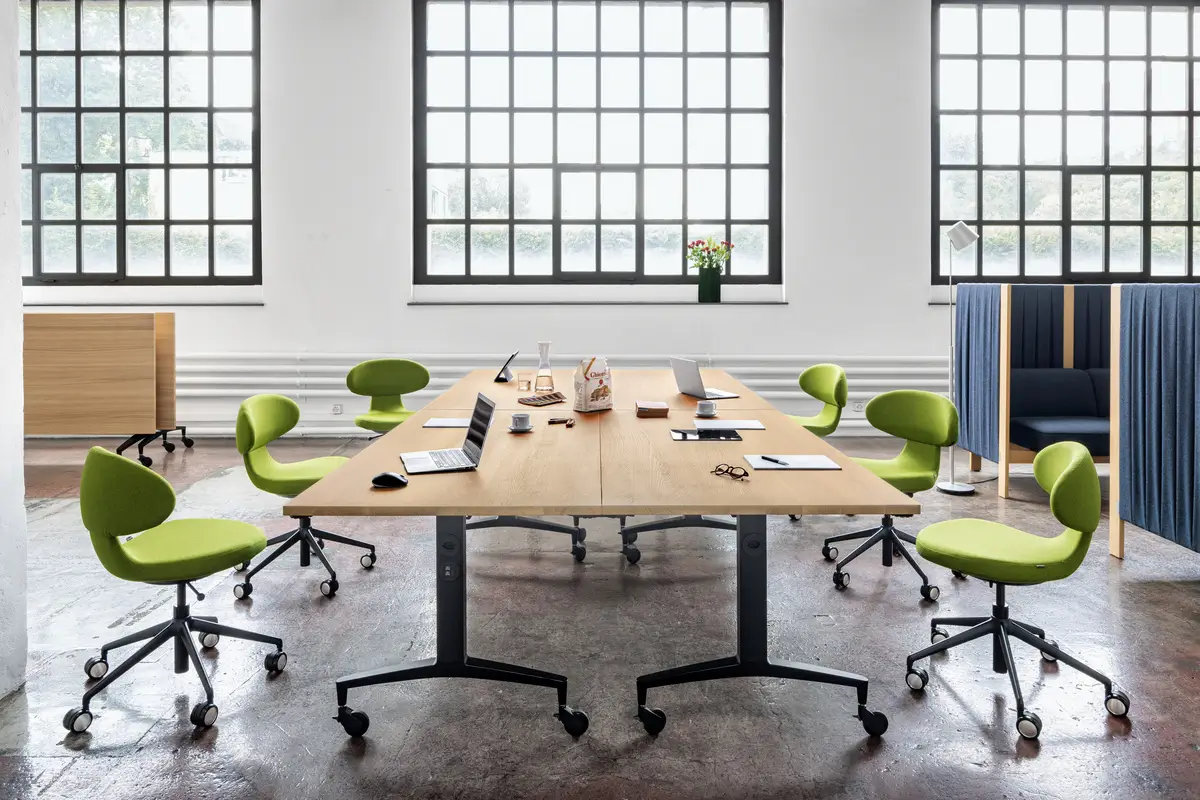 Girsberger Velum Highback Sofa in einem modernen Besprechungsraum mit großem Konferenztisch und Bürostühlen.