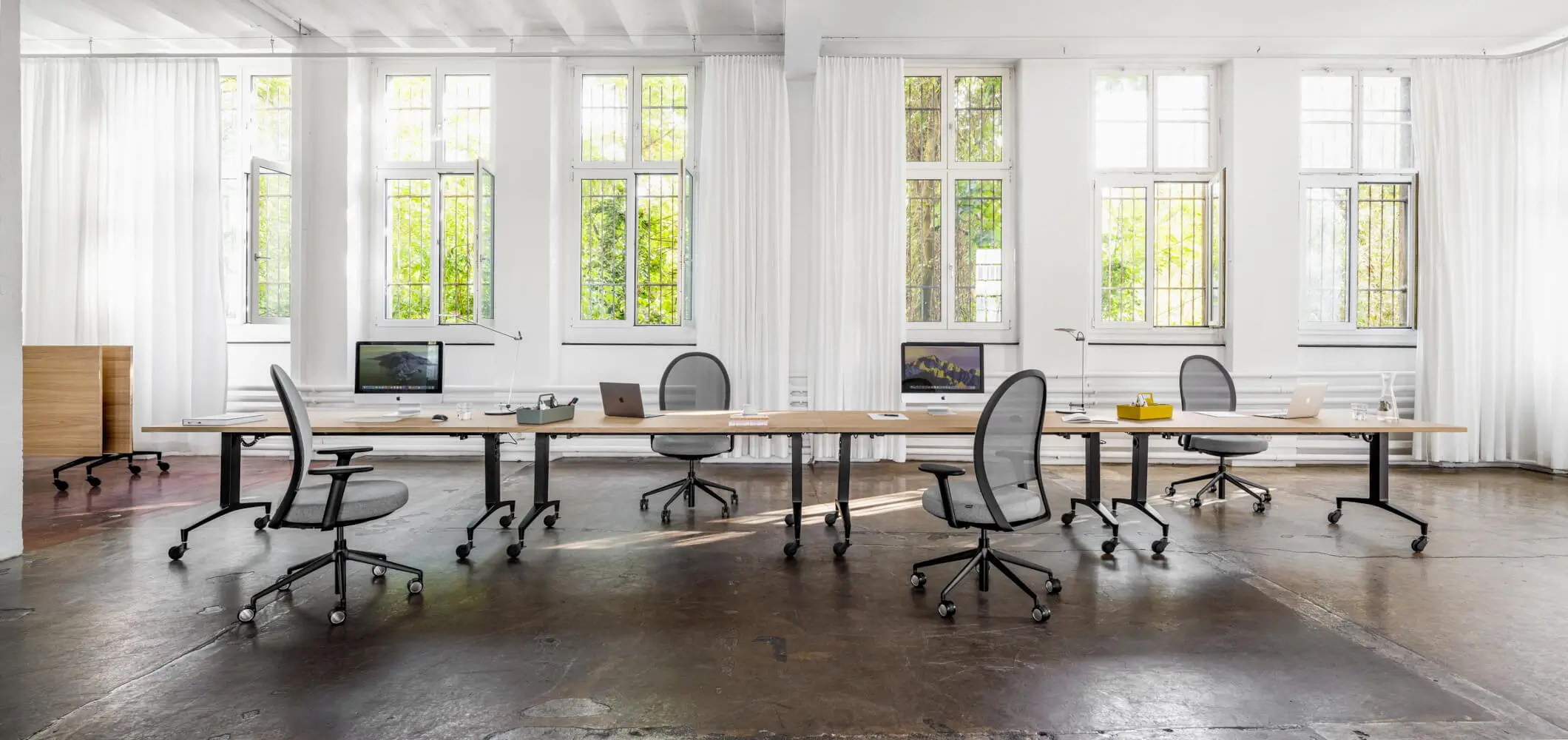 Girsberger Marva Net Bürostuhl an einem großzügigen Arbeitsplatz im modernen Büro.