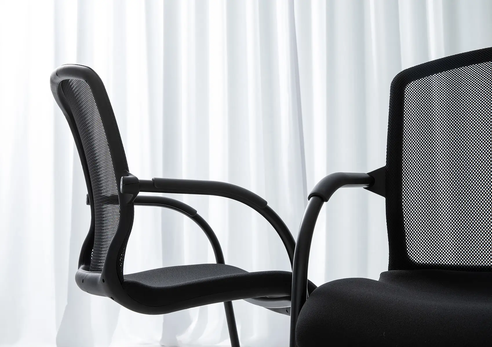 Detailaufnahme des Wagner AluMedic 50 Besucherstuhls mit ergonomischer Netzrückenlehne, gepolstertem Sitz und Armlehnen.