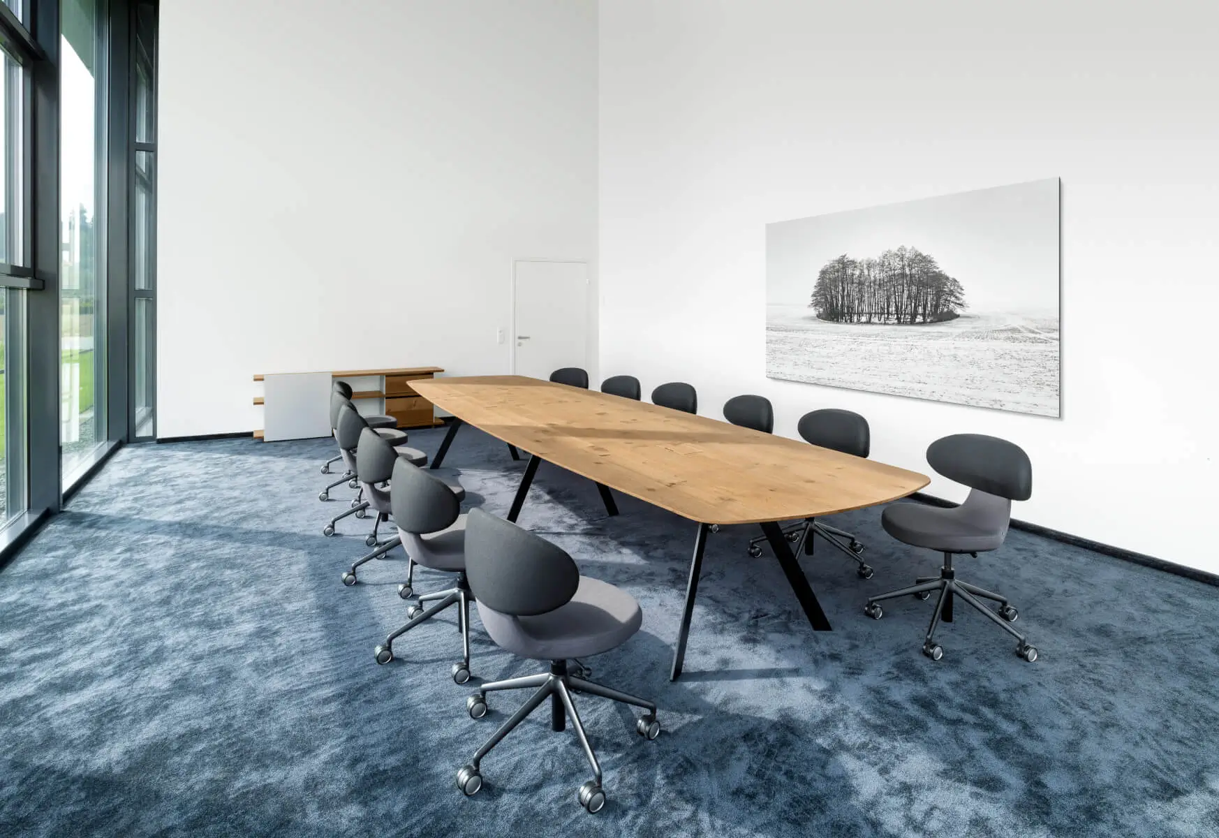 Girsberger Simplex 3D Drehstühle rund um einen großen Konferenztisch in einem modernen Besprechungsraum.