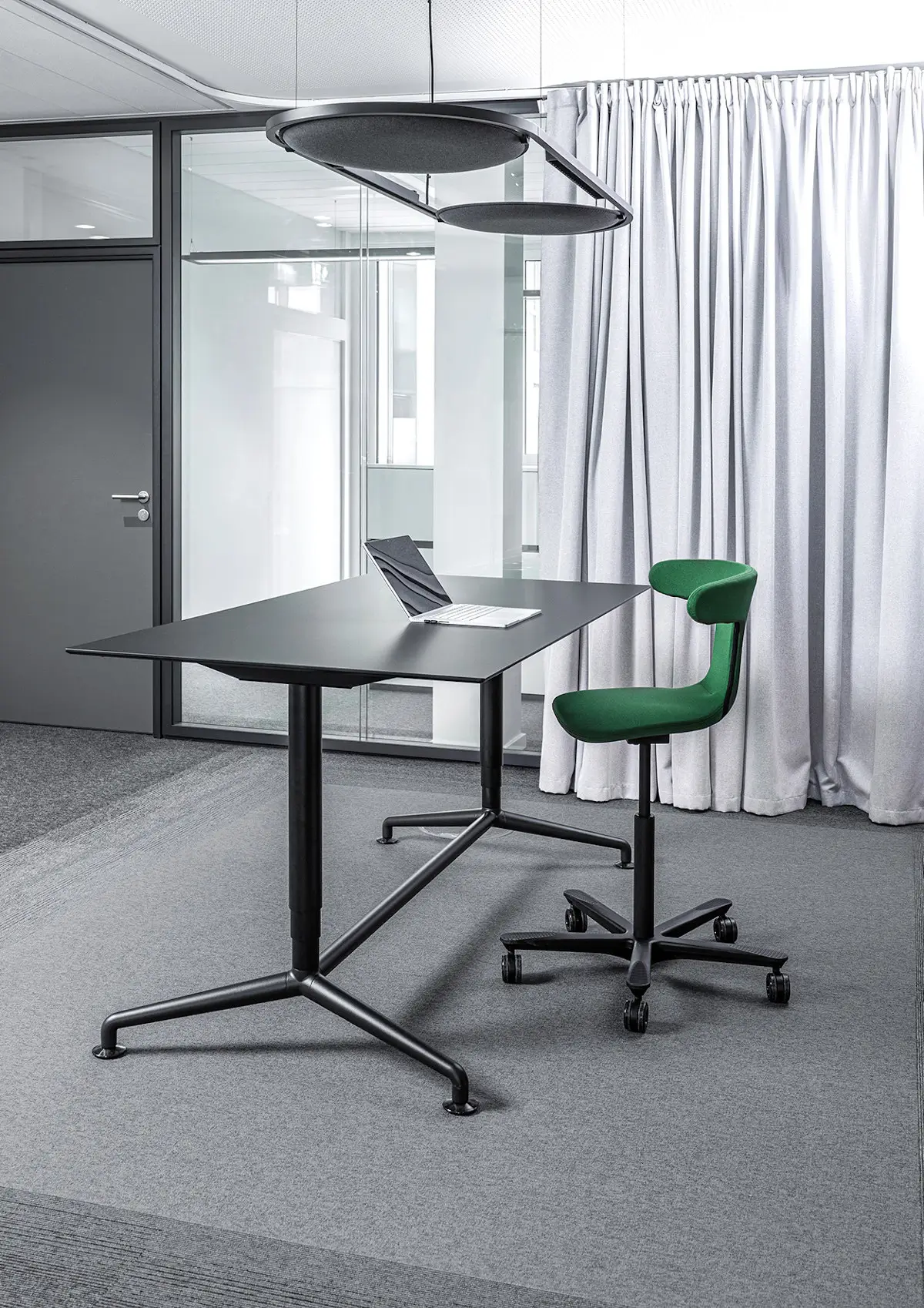 Wagner W-ork Pad Drehstuhl mit grünem Stoffbezug an einem Stehtisch im modernen Büro für ergonomisches und dynamisches Arbeiten.