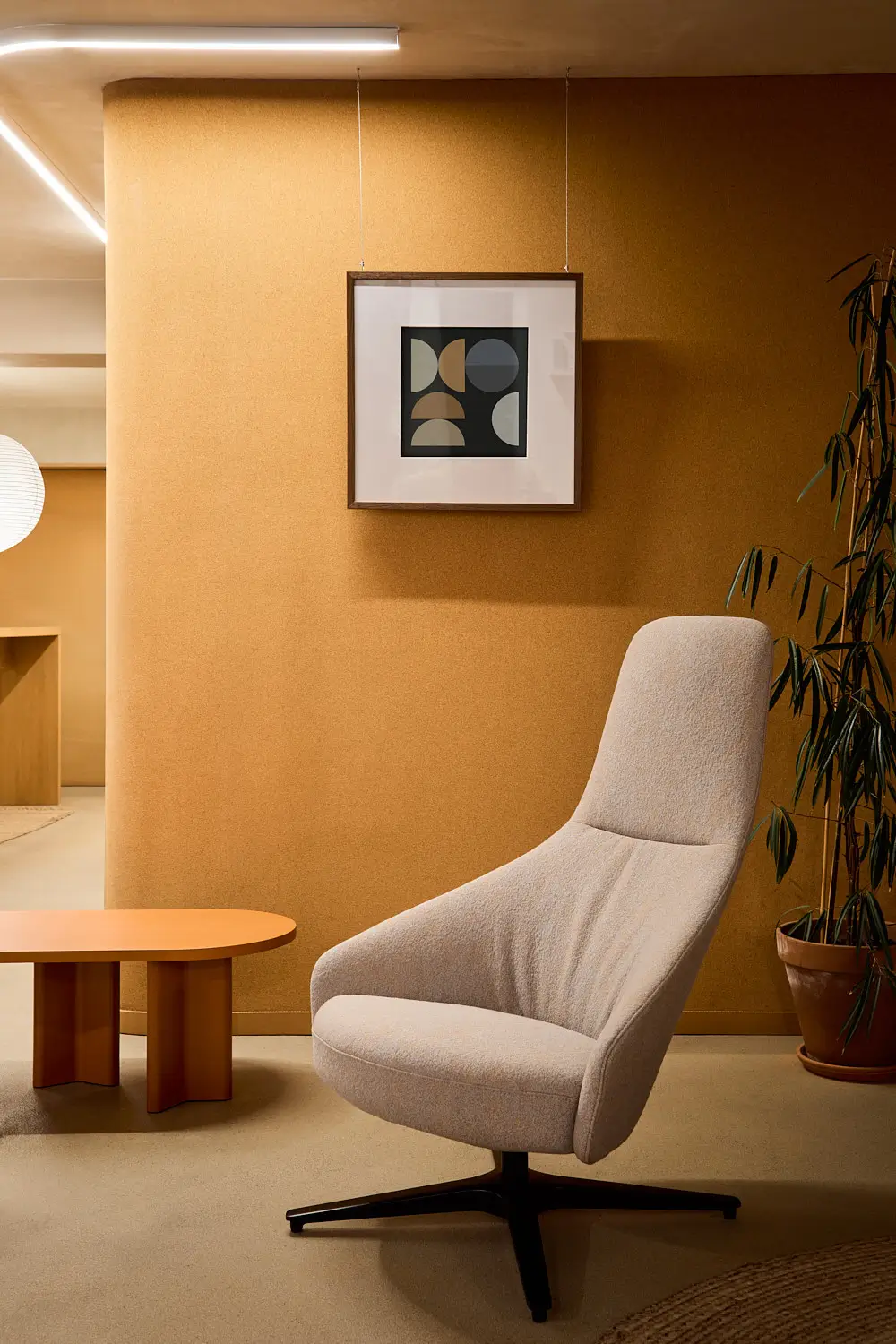 Noti Palo Sessel in Hellbeige mit schwarzem Kreuzgestell in einer stilvollen Lounge mit Beistelltisch