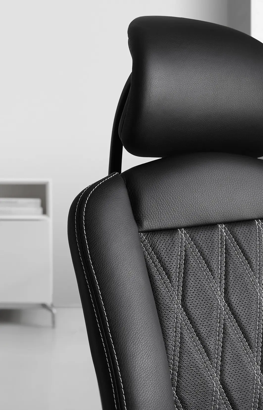 Detailaufnahme des Wagner AluMedic Limited S Bürostuhls mit Kopfstütze, hochwertigem Lederbezug, dekorativer Diamantsteppung und präziser Kontrastnaht.