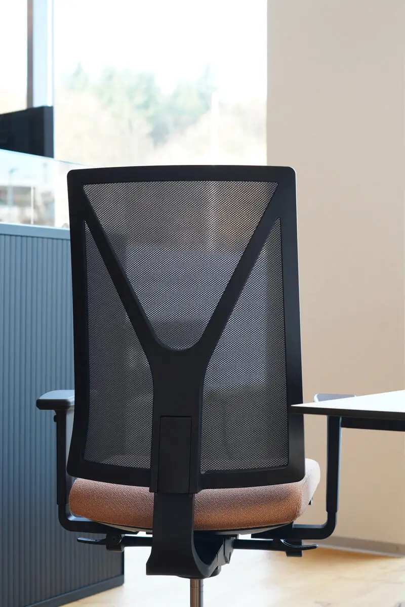 Detailansicht des Girsberger Yanos Drehstuhls mit charakteristischem Netzrücken und Armlehnen.