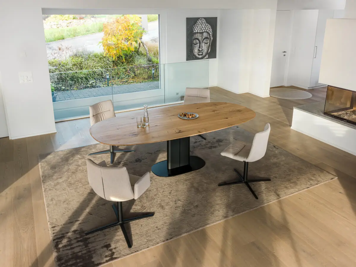 Girsberger Amieta Work Tisch mit Holzplatte in einem hellen Wohnbereich mit Sitzstühlen