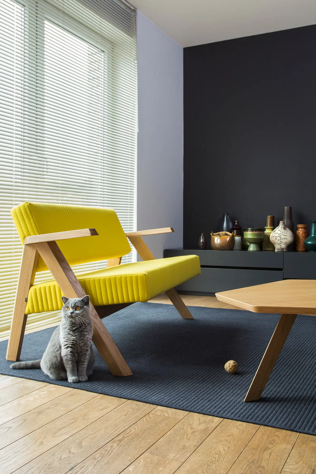 Noti Clapp Sofa 2-Sitzer in Gelb mit Holzgestell und Armlehnen im modernen Wohnbereich