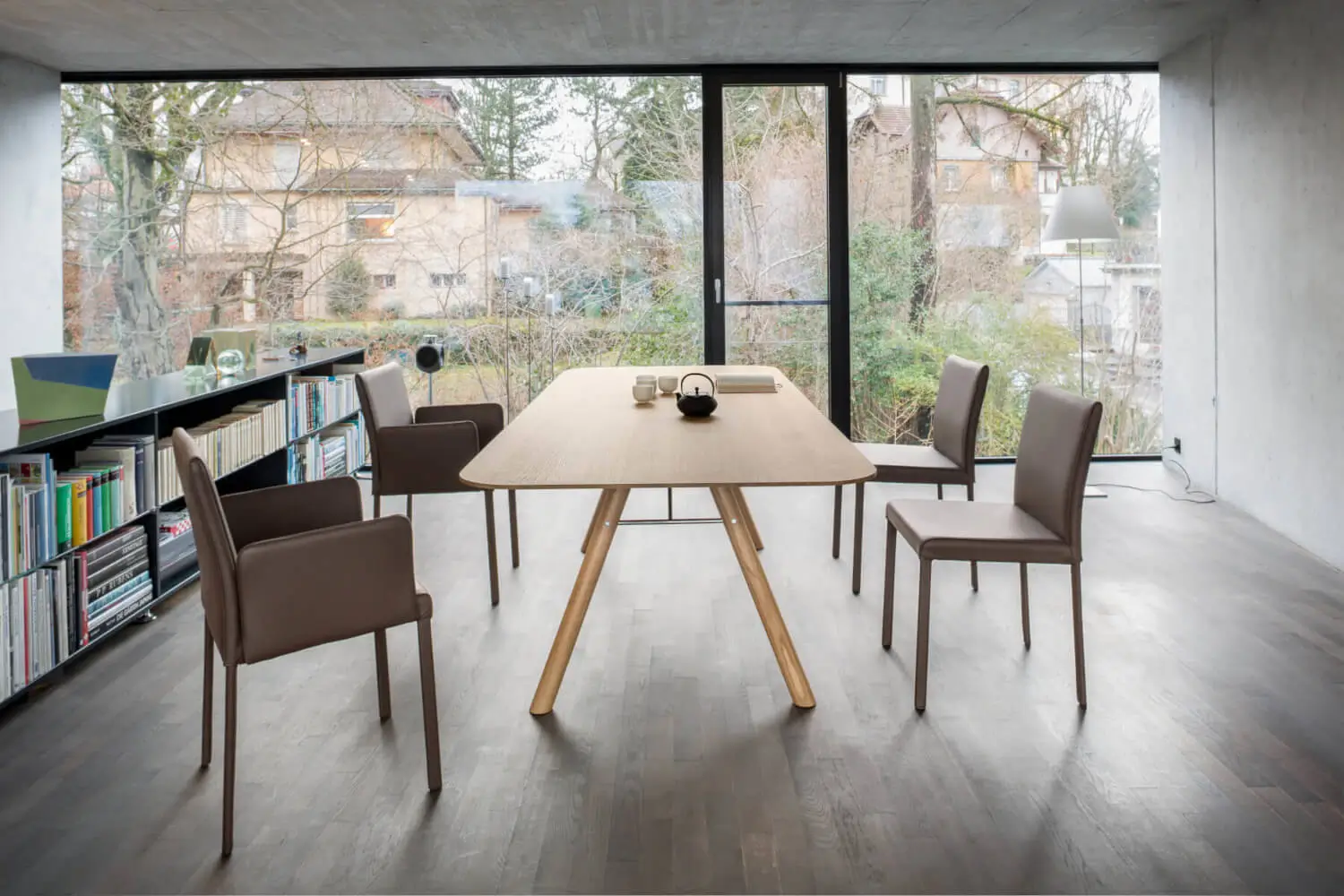 Girsberger Akio Tisch aus Massivholz im modernen Esszimmer mit großzügiger Fensterfront.