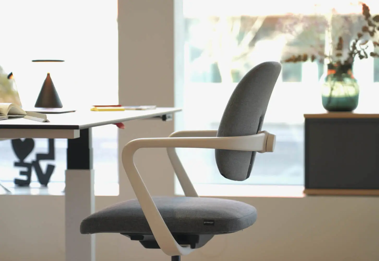 Girsberger Ategra Bürostuhl an einem modernen Homeoffice-Arbeitsplatz mit höhenverstellbarem Schreibtisch.