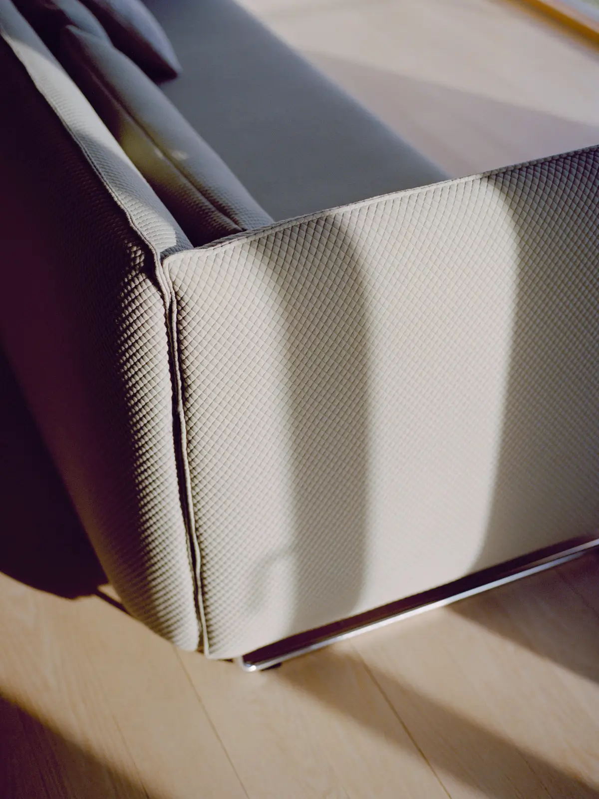 Softline Metro Sofa in Hellgrau in naher Detailansicht mit strukturierter Polsterung, gepolsterter Armlehne und sichtbarem Metallfuß.