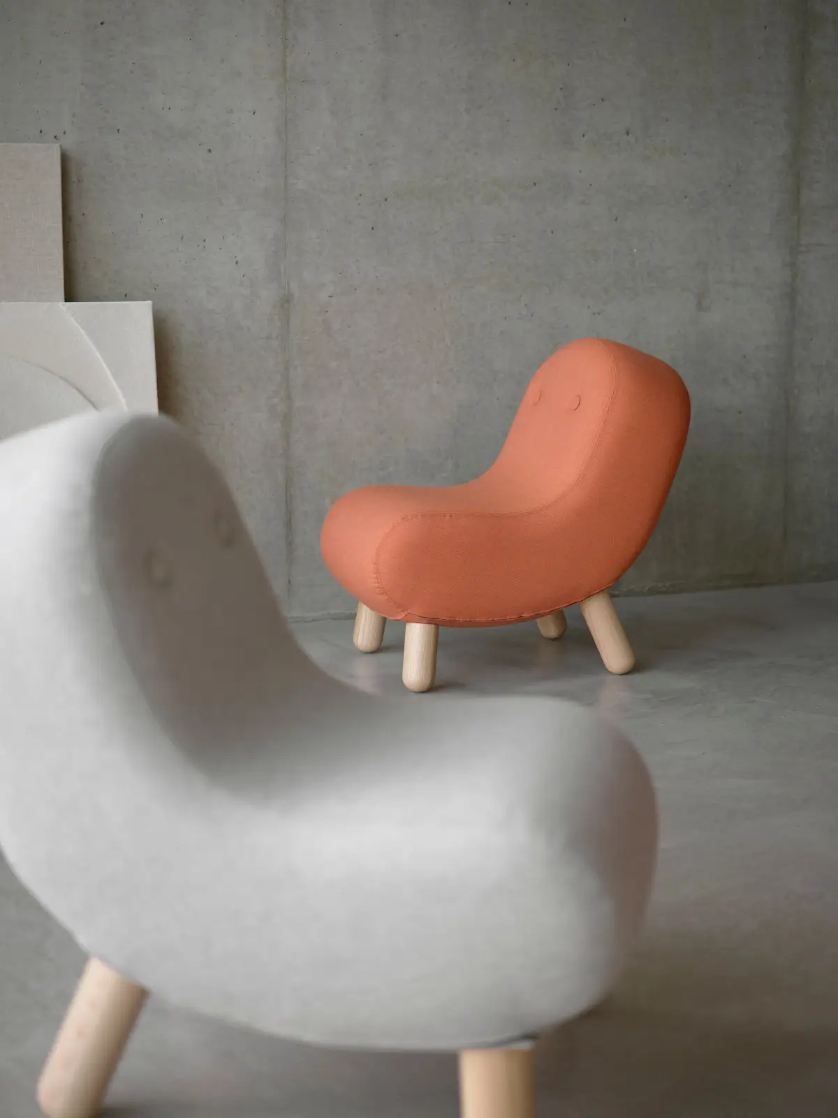 Softline Bob Sessel in Orange mit geschwungener Polsterform und hellen Holzbeinen in einem modernen Wohnambiente.