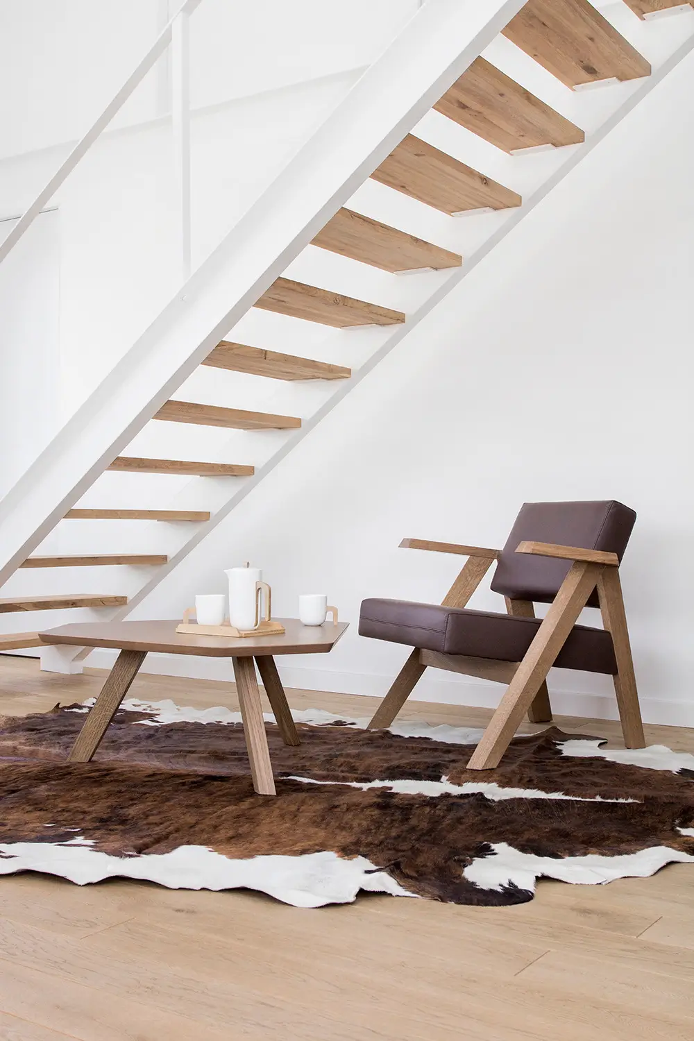 Noti Clapp Sessel in Braun mit Holzgestell und Armlehnen in einem modernen Wohnambiente