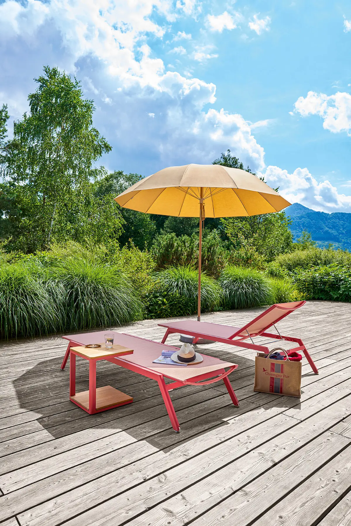 Weishäupl Pagodenschirm spendet Schatten über Sonnenliegen auf einer Holzterrasse