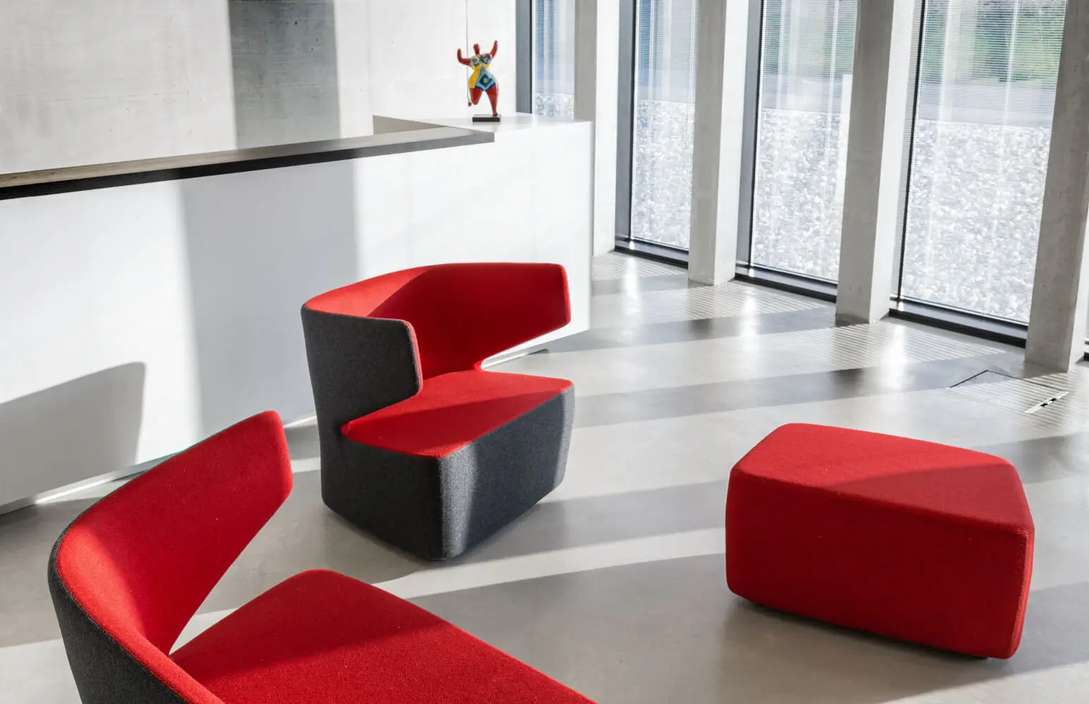 Girsberger Pablo Sessel mit Pouf als einladende Sitzmöbel in einem modernen Wartebereich.