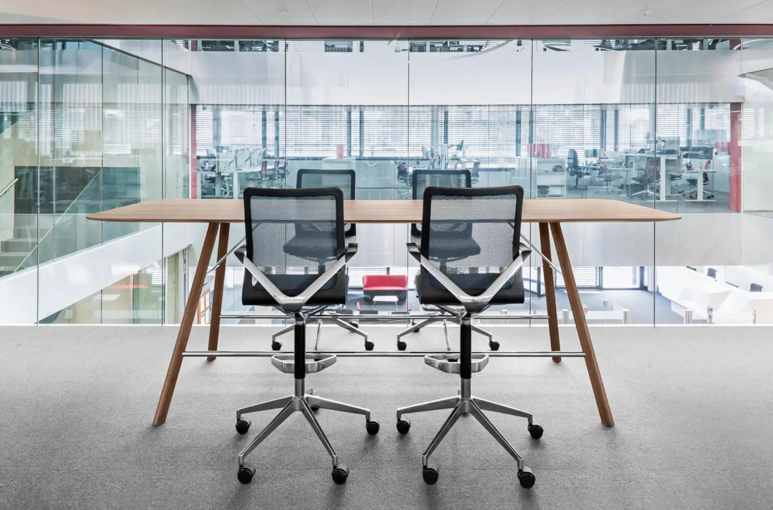 Girsberger Linq Drehstühle mit Fußbügel an einem hohen Besprechungstisch im Büro