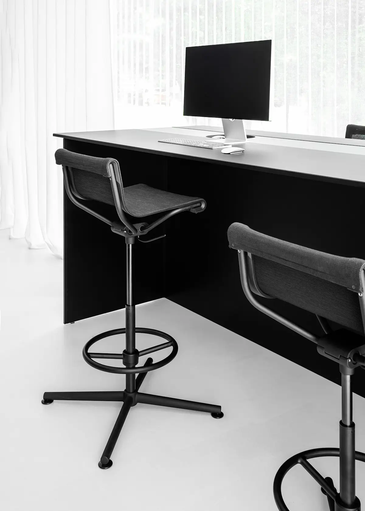 Wagner d1 Highstool in hoher Ausführung an einem modernen Schreibtisch mit Monitor im Büro.