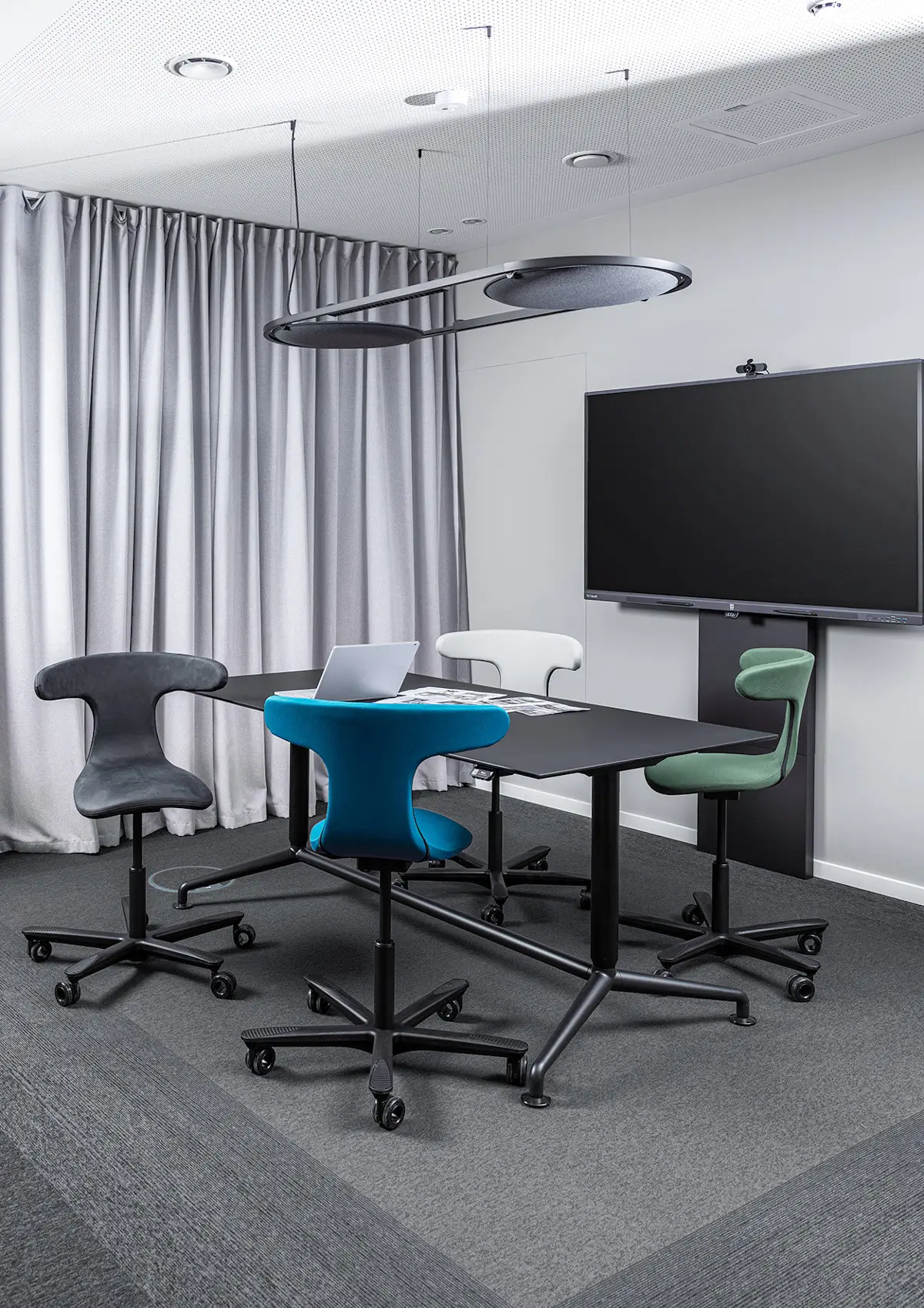 Wagner W-ork Pad Drehstühle in verschiedenen Farben an einem Konferenztisch im modernen Besprechungsraum für flexible Teamarbeit.
