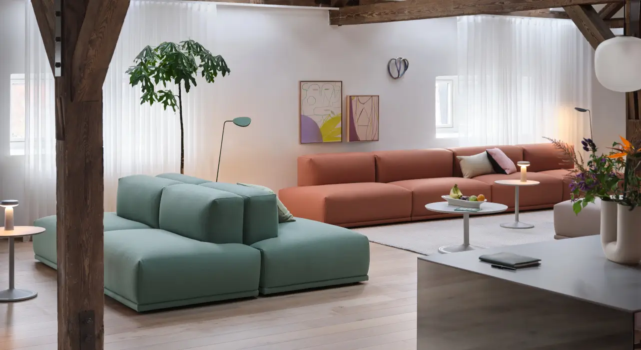 Wohnzimmer unter dem Dach mit niedrigen Sofas und sichtbaren Holzbalken