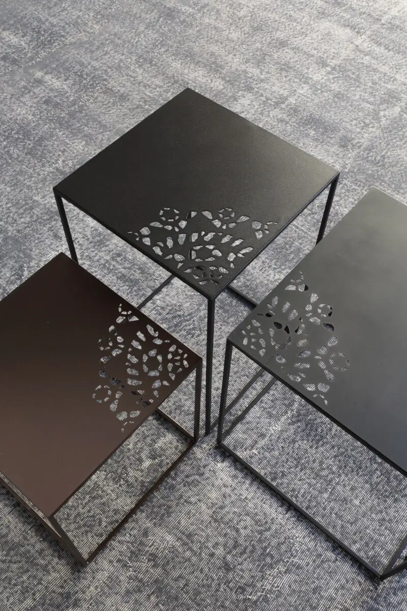 Detailansicht der Zeus Slim Charme Beistelltische mit dekorativ gelaserter Stahlplatte und filigraner Rahmenkonstruktion.