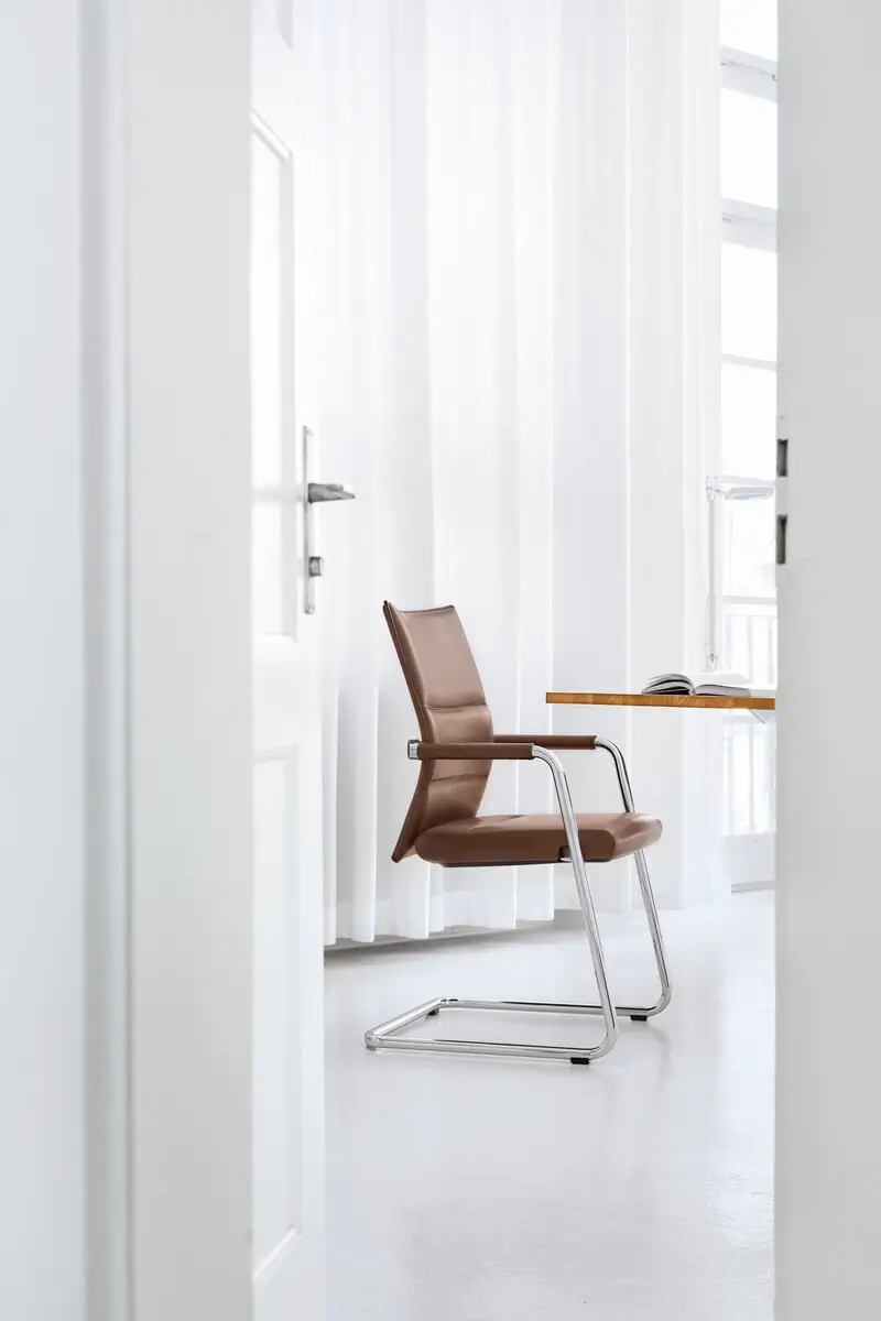 Girsberger Diagon Executive Freischwinger als elegante Sitzgelegenheit in einem hellen und modernen Büroraum.