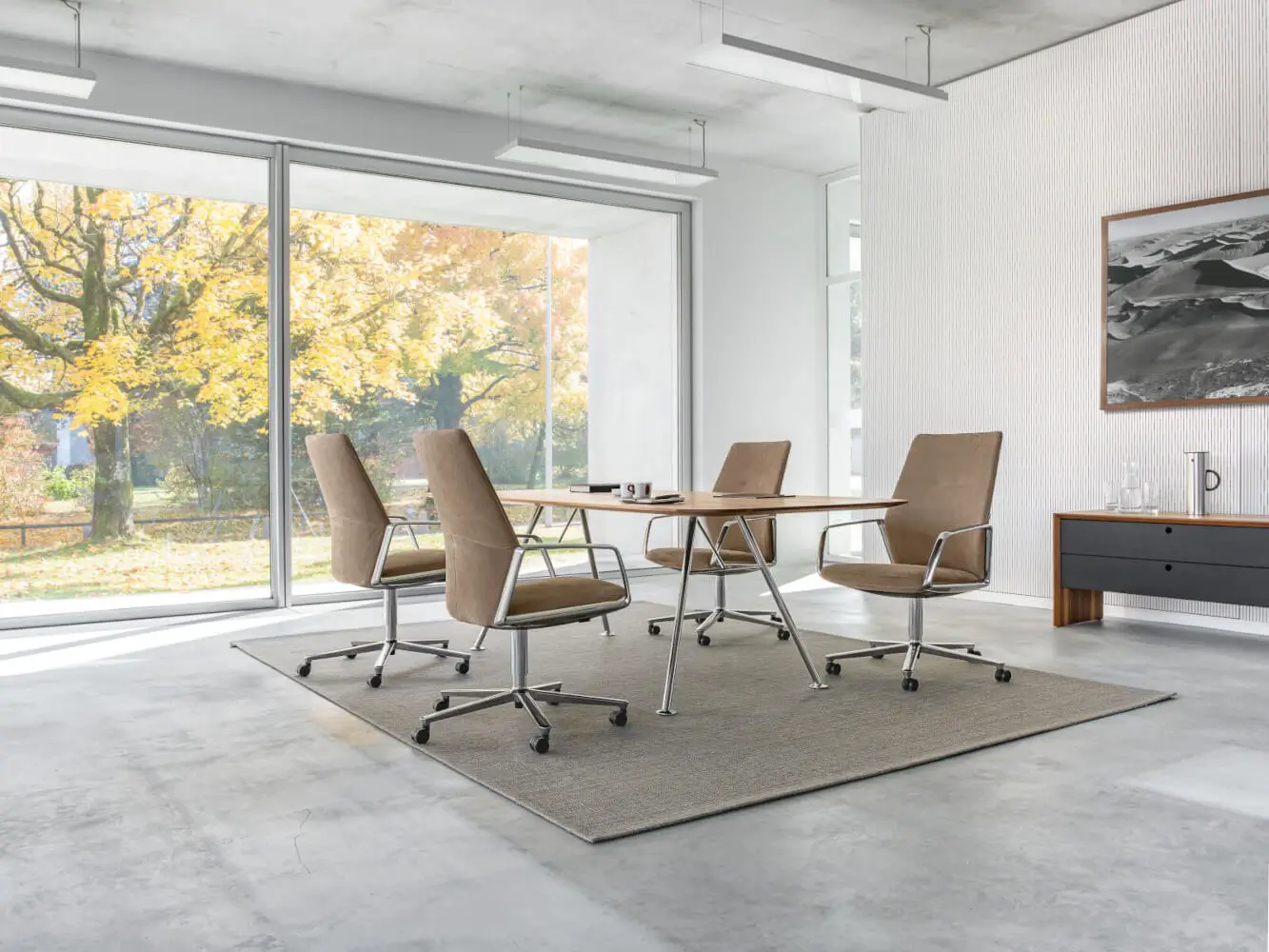 Girsberger Akio Steel Tisch in einem Arbeitszimmer mit historischem Mauerwerk.