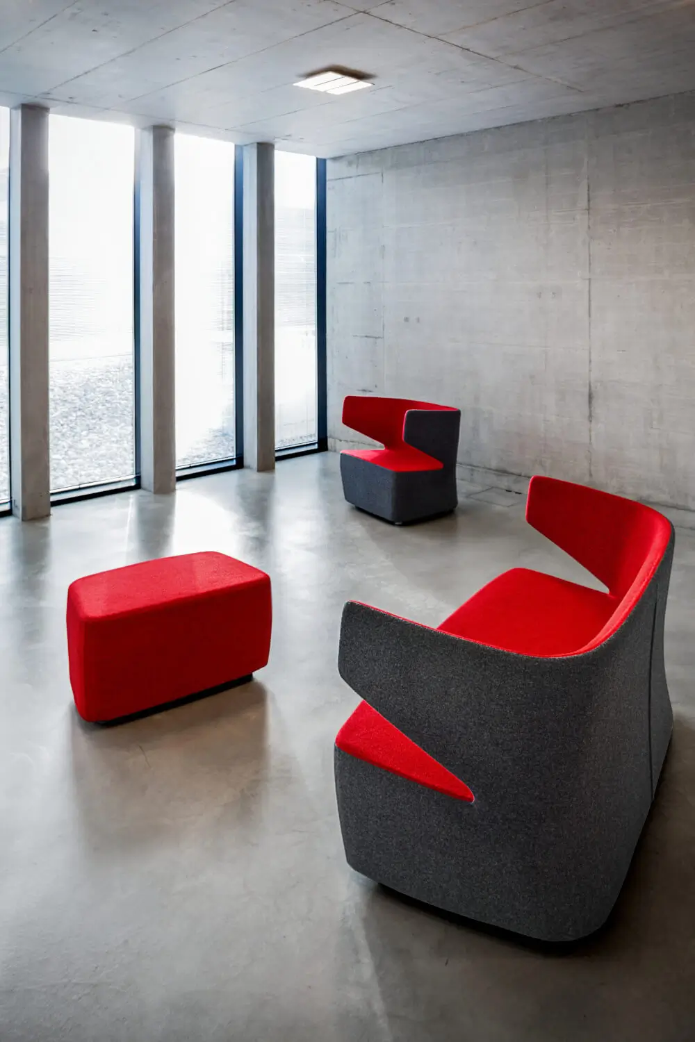 Girsberger Pablo Sessel und Pouf als moderne Lounge-Sitzgruppe in einem klar gestalteten Interieur.