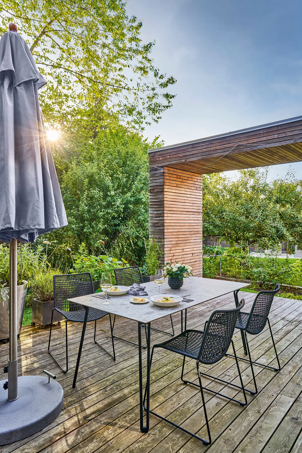 Weishäupl Trendschirm 350 x 350 cm in Eukalyptus auf einer modernen Holzterrasse mit Essgruppe im Garten