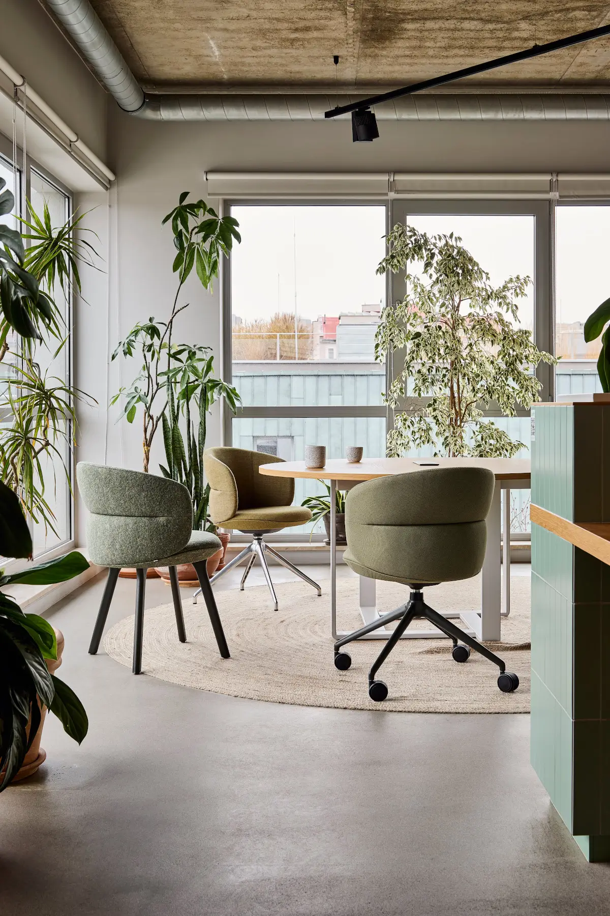Noti Ekori Stuhl in Beige mit Holzbeinen an einem Tisch im modernen Besprechungsraum